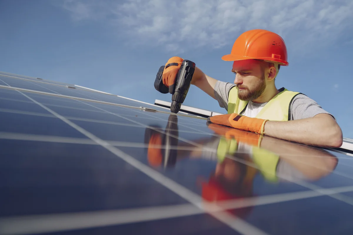 An installer fitting a solar panel outdoors